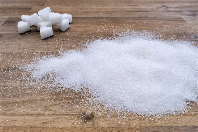 how much sugar per day photo of sugar on wooden table