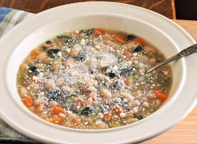 photo of vegetarian white bean soup in white bowl with spoon