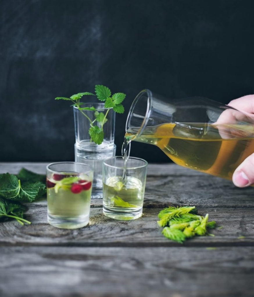 photo of spruce tip liqueur pouring from carafe into glass