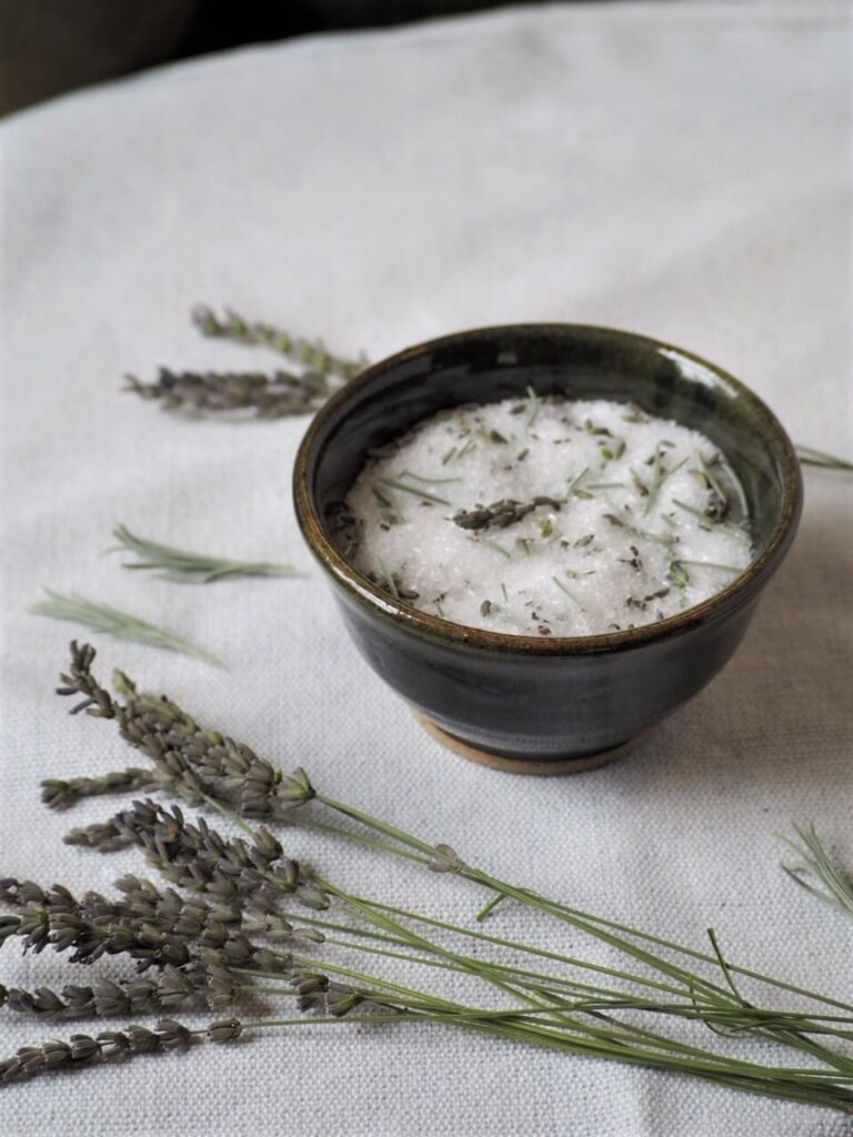 photo of lavender bath salts in bowl and dried lavender on table