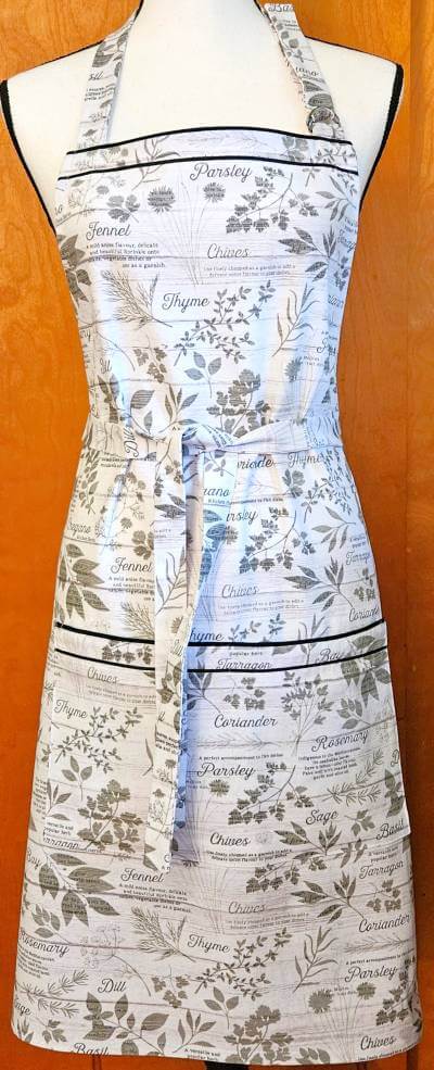photo of white kitchen apron with black herbal designs