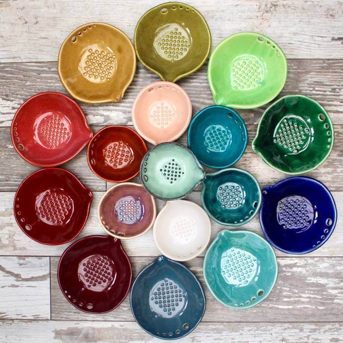 photo of colorful ceramic bowls with holes for stripping herbs