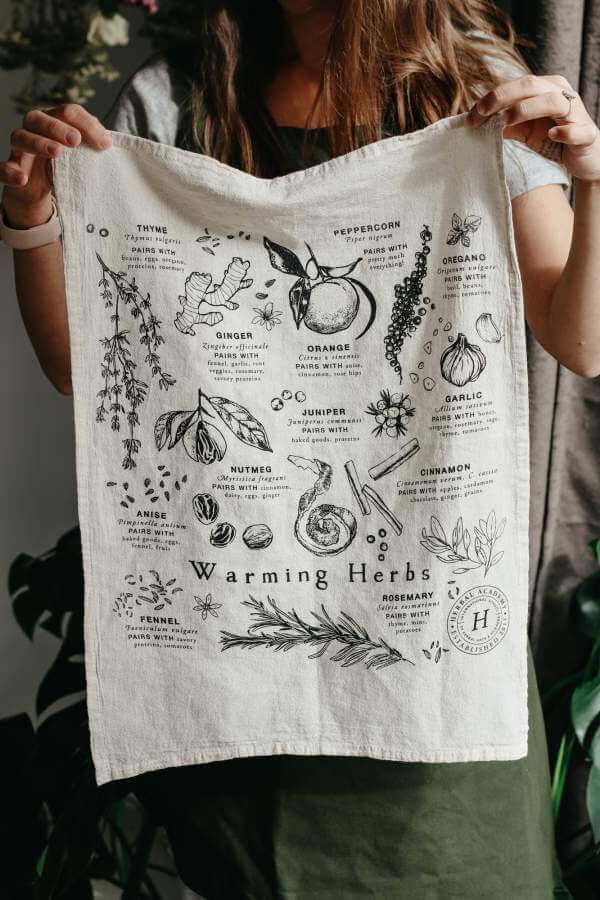 photo of white tea towel printed with images of warming herbs 