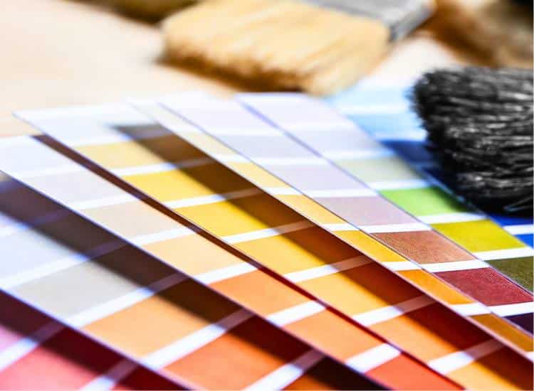 photo of paint color strips with paint brushes on a table