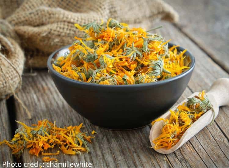 photo of dried calendula flowers in wooden bowl