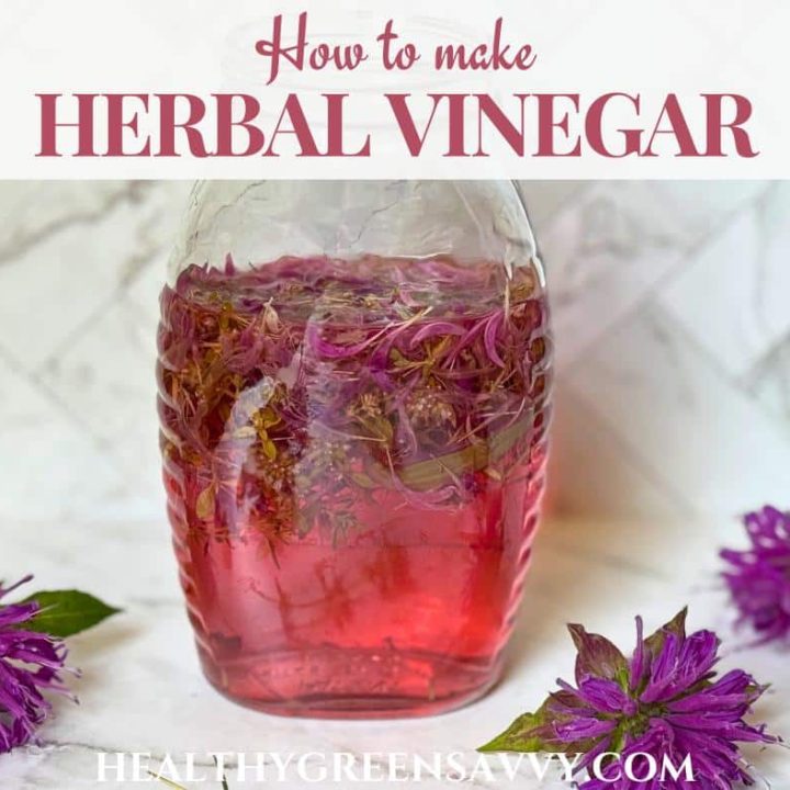 cover photo of herbal vinegar in glass jar with bee balm flowers on marble counter
