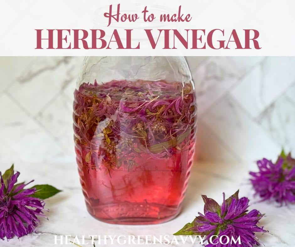 cover photo of herbal vinegar in glass jar with bee balm flowers on marble counter